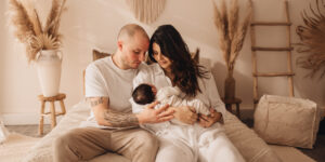 Paar hält Baby im Arm in einem Boho Setting